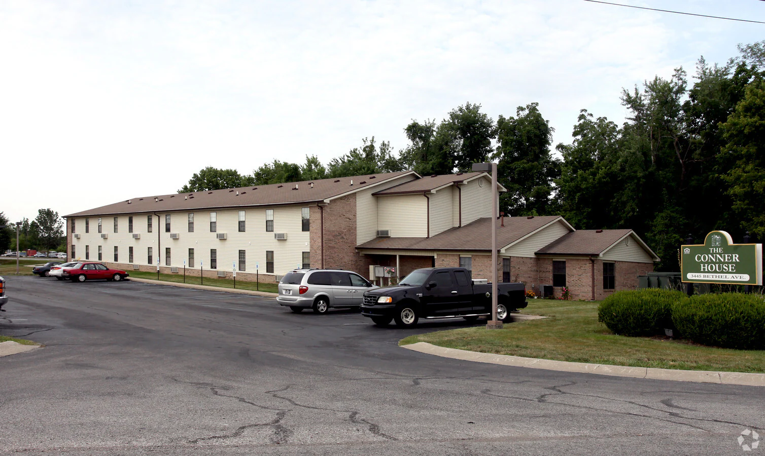 A parking lot in front of a building with a sign that says Conner House.